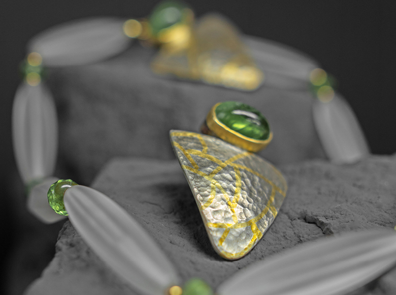Ein Set bestehend aus zwei Ohrringen und einer Kette. Die verwendeten Perle und Steine sind grün.